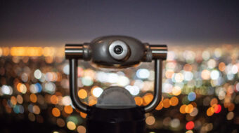 close-up-coin-operated-binoculars-against-illuminated-cityscape