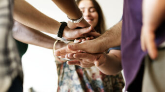 Group of diverse people joined hands together teamwork