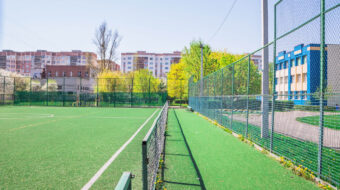 soccer-field-with-artificial-green-grass-near-school-amateur-football-field-sunny-summer-day